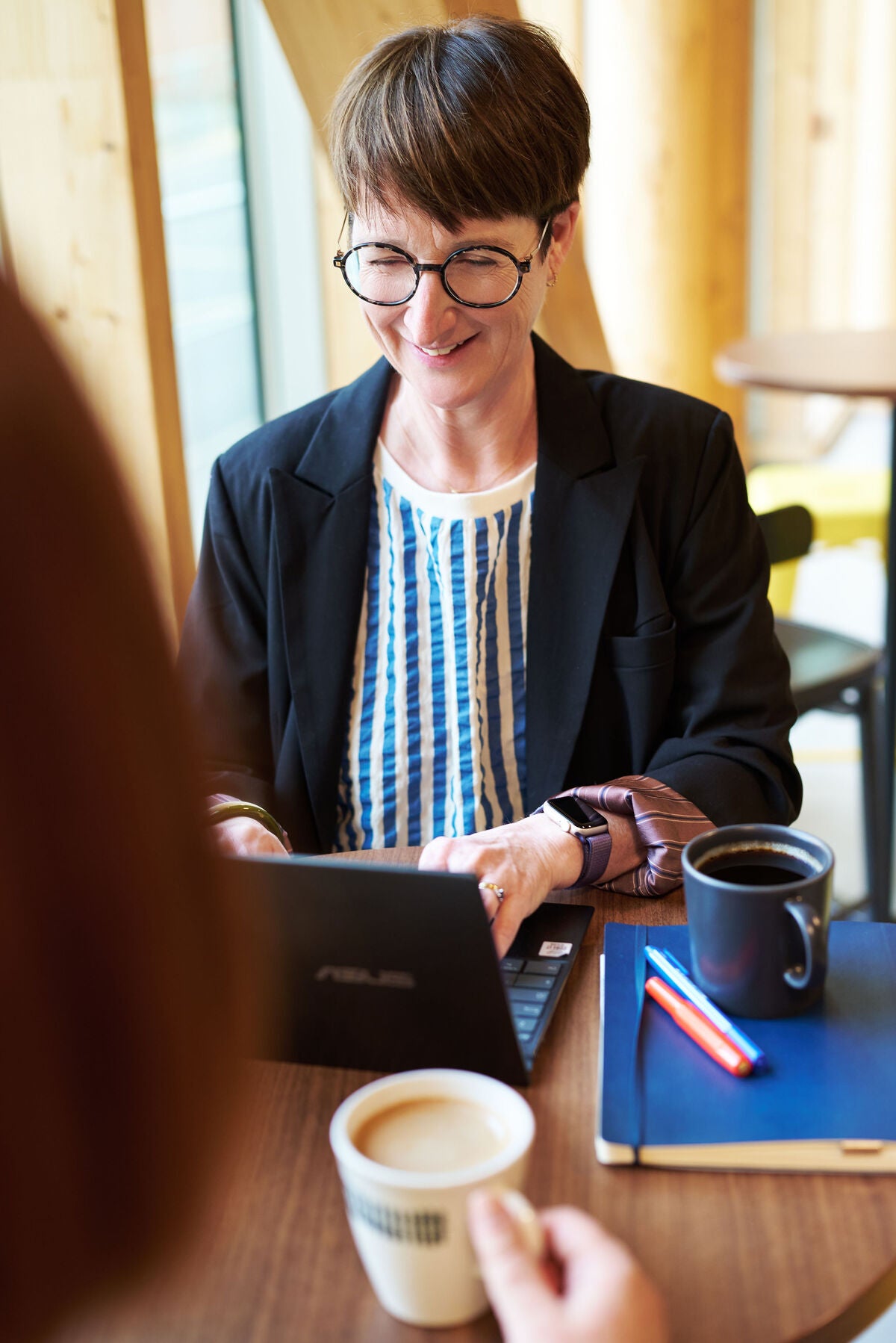 Blouse bleu et blanche veste noire et devant ordinateur