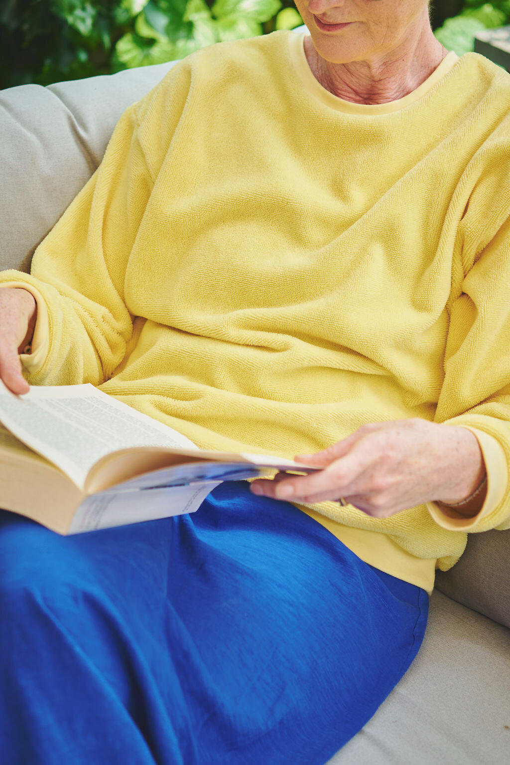 Sweat jaune jupe bleu klein assis sur un canapé